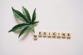 Cannabis leaf alongside Scrabble tiles spelling 'medicine', highlighting natural remedies.